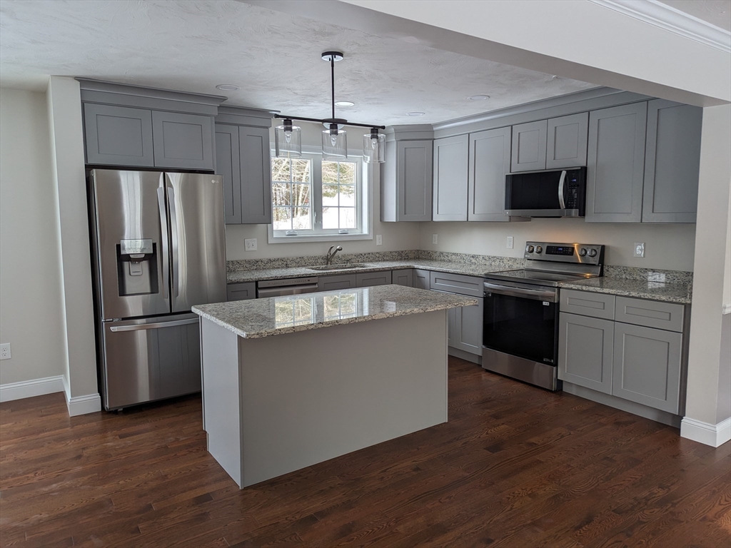 Lot 5-510 Old County Road Wales, MA 01081 - Photo 4 of 32 a kitchen with stainless steel appliances granite countertop a refrigerator a sink a stove a microwave and wooden floors