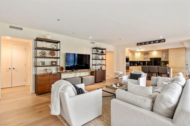 a living room with furniture a flat screen tv and a large window