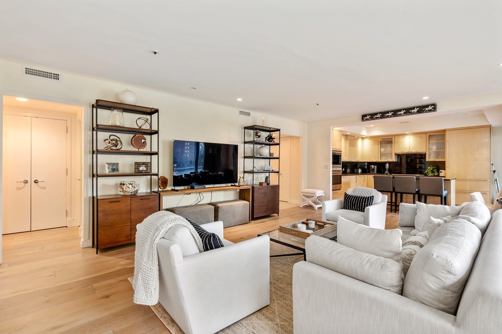 20 Rowes Wharf, Unit 306 Boston, MA 02110 - Photo 3 of 14 a living room with furniture a flat screen tv and a large window