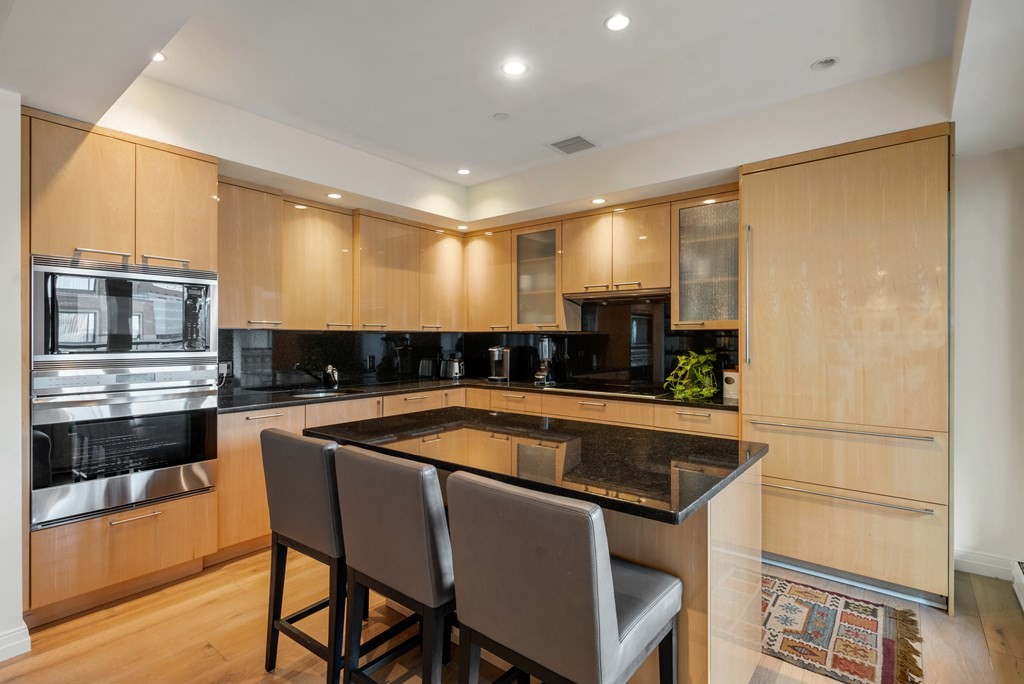 20 Rowes Wharf, Unit 306 Boston, MA 02110 - Photo 4 of 14 a kitchen with stainless steel appliances granite countertop a sink and a microwave