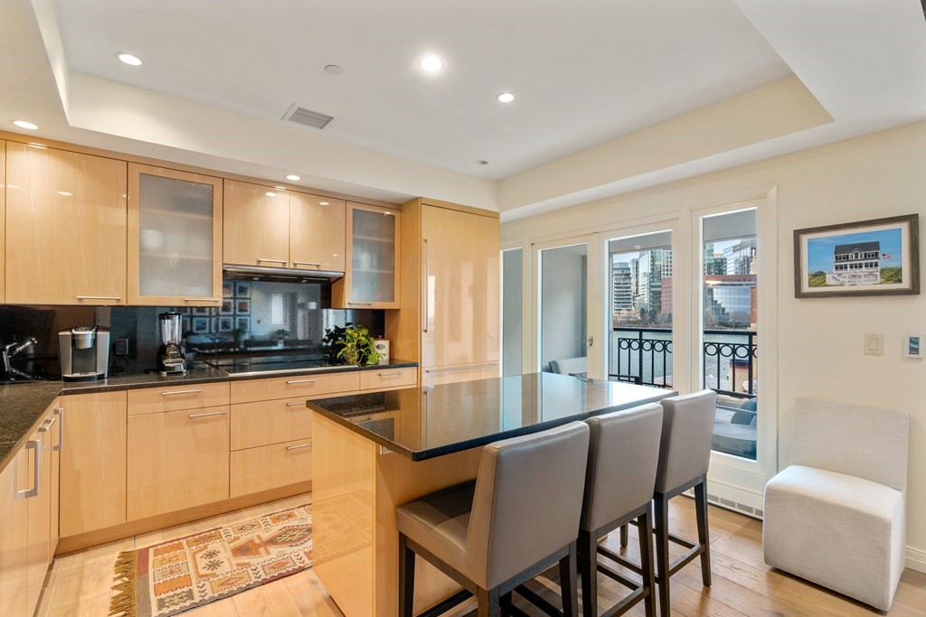 20 Rowes Wharf, Unit 306 Boston, MA 02110 - Photo 5 of 14 a kitchen with stainless steel appliances granite countertop a stove top oven a sink a dining table and chairs