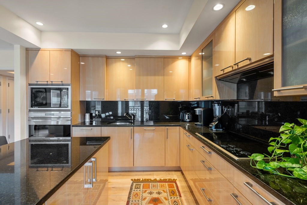 20 Rowes Wharf, Unit 306 Boston, MA 02110 - Photo 6 of 14 a kitchen with stainless steel appliances kitchen island granite countertop a stove a sink and a microwave
