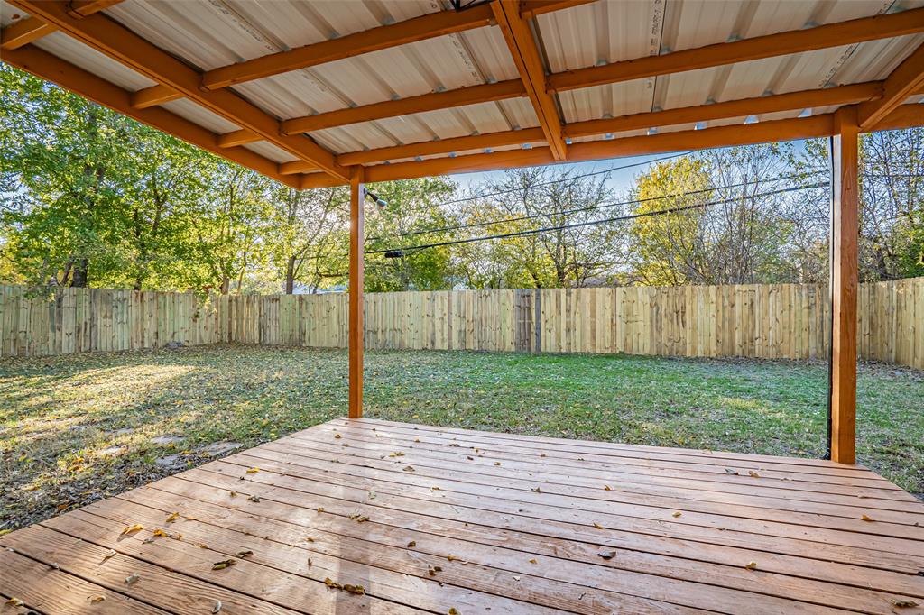 6901 Bennington Drive Watauga, TX 76148 - Photo 12 of 36 a backyard of a house with trees and a wooden fence