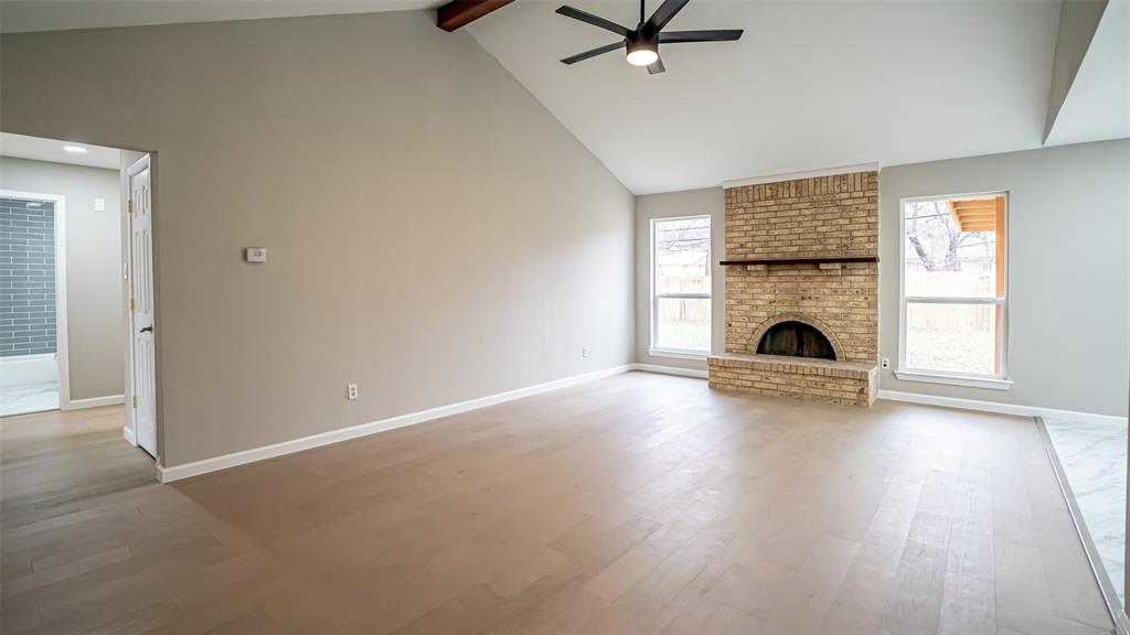 6901 Bennington Drive Watauga, TX 76148 - Photo 15 of 36 an empty room with fireplace wooden floor and window