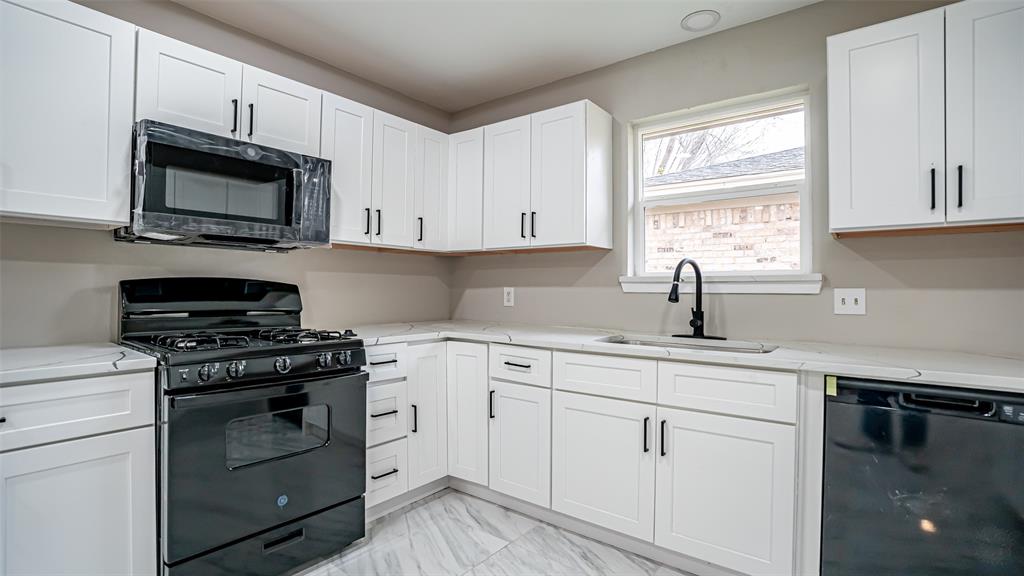 6901 Bennington Drive Watauga, TX 76148 - Photo 18 of 36 a kitchen with white cabinets stainless steel appliances and sink