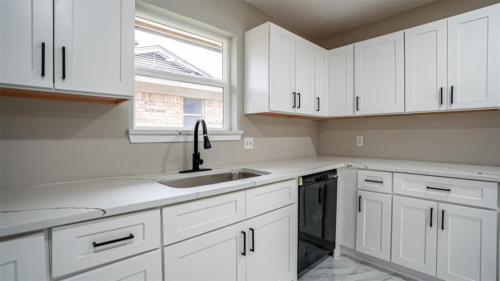 6901 Bennington Drive Watauga, TX 76148 - Photo 20 of 36 a kitchen with white cabinets and a window