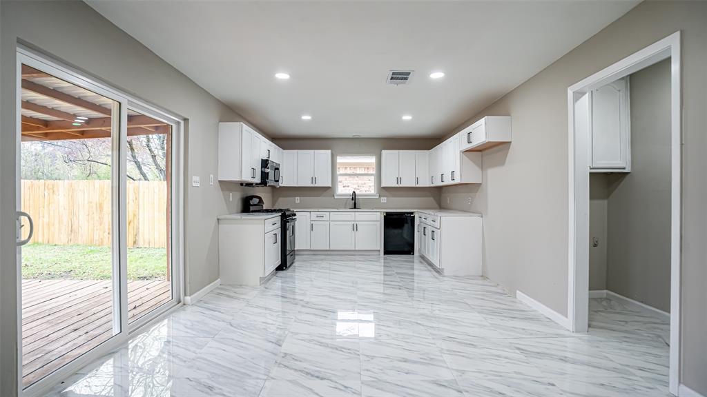 6901 Bennington Drive Watauga, TX 76148 - Photo 21 of 36 a kitchen with stainless steel appliances granite countertop a refrigerator a sink dishwasher a stove and white countertops with wooden floor