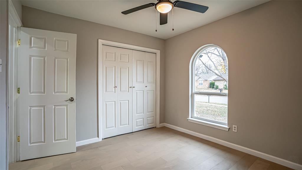 6901 Bennington Drive Watauga, TX 76148 - Photo 31 of 36 an empty room with chandelier fan and windows