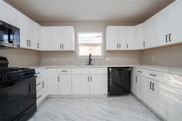 a kitchen with cabinets appliances a sink and a window