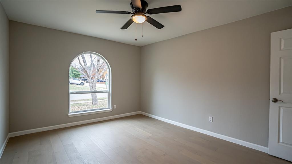 6901 Bennington Drive Watauga, TX 76148 - Photo 33 of 36 an empty room with windows and ceiling fan