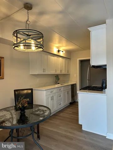 a kitchen with a sink cabinets and wooden floor