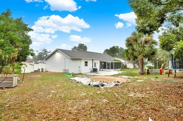 a view of a yard in front of a house with large trees