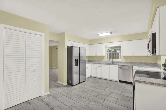 a kitchen with a sink refrigerator and cabinets