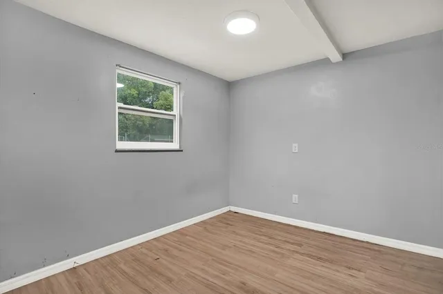 wooden floor in an empty room with a window