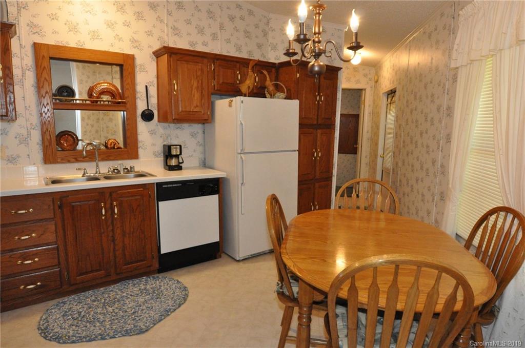 1153 Hopps Road, Unit 46 Chester, SC 29706 - Photo 3 of 22 a kitchen with a table chairs and a refrigerator