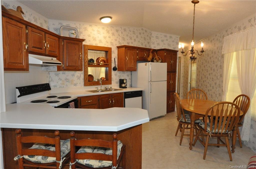 1153 Hopps Road, Unit 46 Chester, SC 29706 - Photo 4 of 22 a kitchen with stainless steel appliances a stove a refrigerator a sink a dining table and chairs