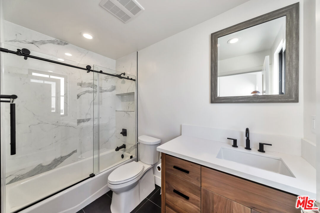 1022-1024 Masselin Avenue Los Angeles, CA 90036 - Photo 11 of 16 a bathroom with a sink a toilet and shower