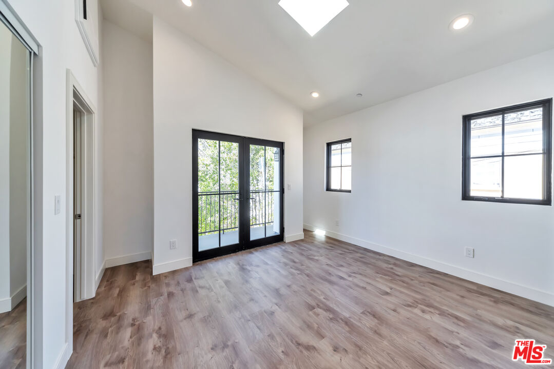 1022-1024 Masselin Avenue Los Angeles, CA 90036 - Photo 12 of 16 a view of an empty room with wooden floor and a window