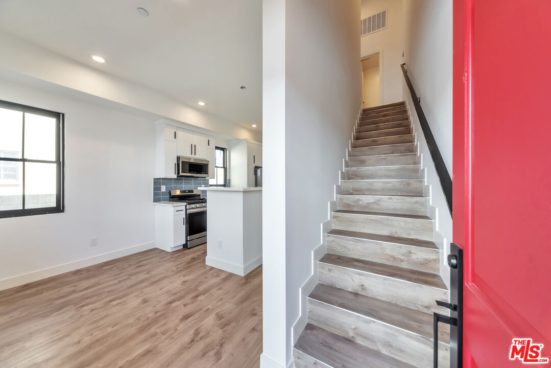 1022-1024 Masselin Avenue Los Angeles, CA 90036 - Photo 2 of 16 a view of a kitchen with wooden floor and electronic appliances