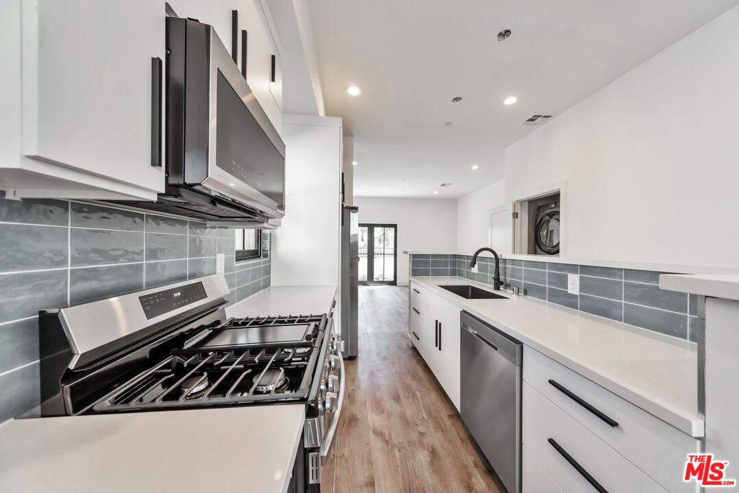 1022-1024 Masselin Avenue Los Angeles, CA 90036 - Photo 6 of 16 a kitchen with a stove and a refrigerator