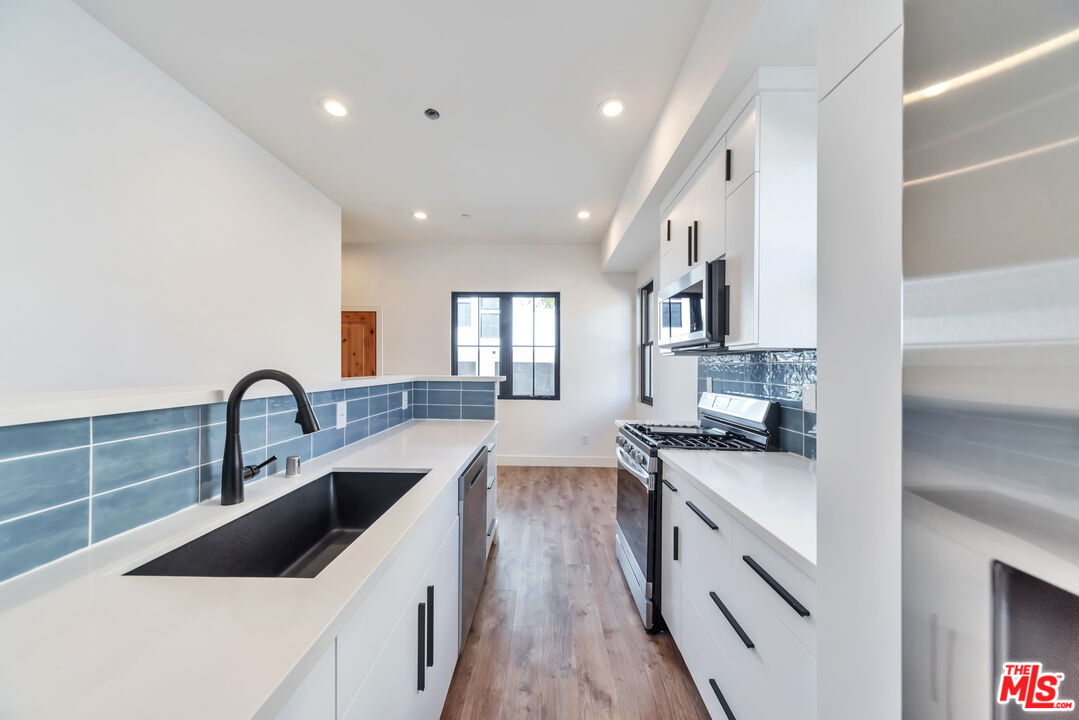 1022-1024 Masselin Avenue Los Angeles, CA 90036 - Photo 7 of 16 a kitchen with granite countertop a sink and cabinets