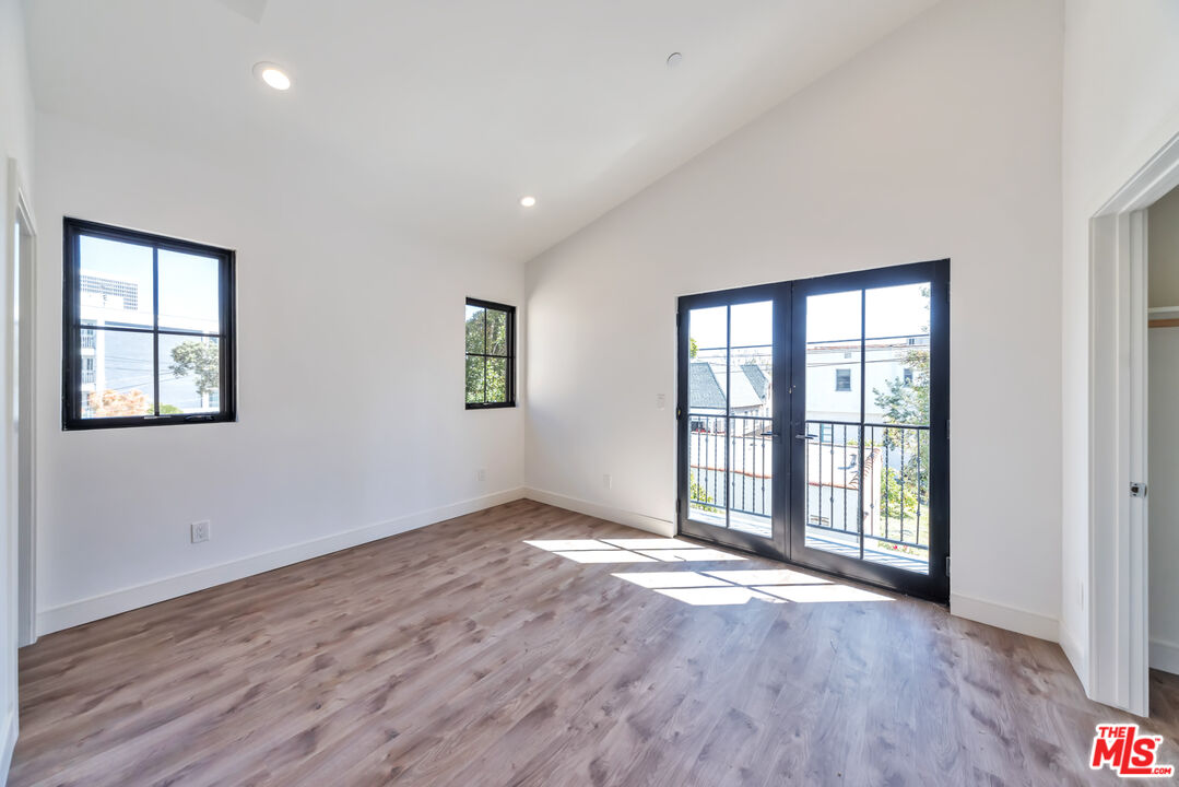 1022-1024 Masselin Avenue Los Angeles, CA 90036 - Photo 10 of 16 an empty room with wooden floor and windows