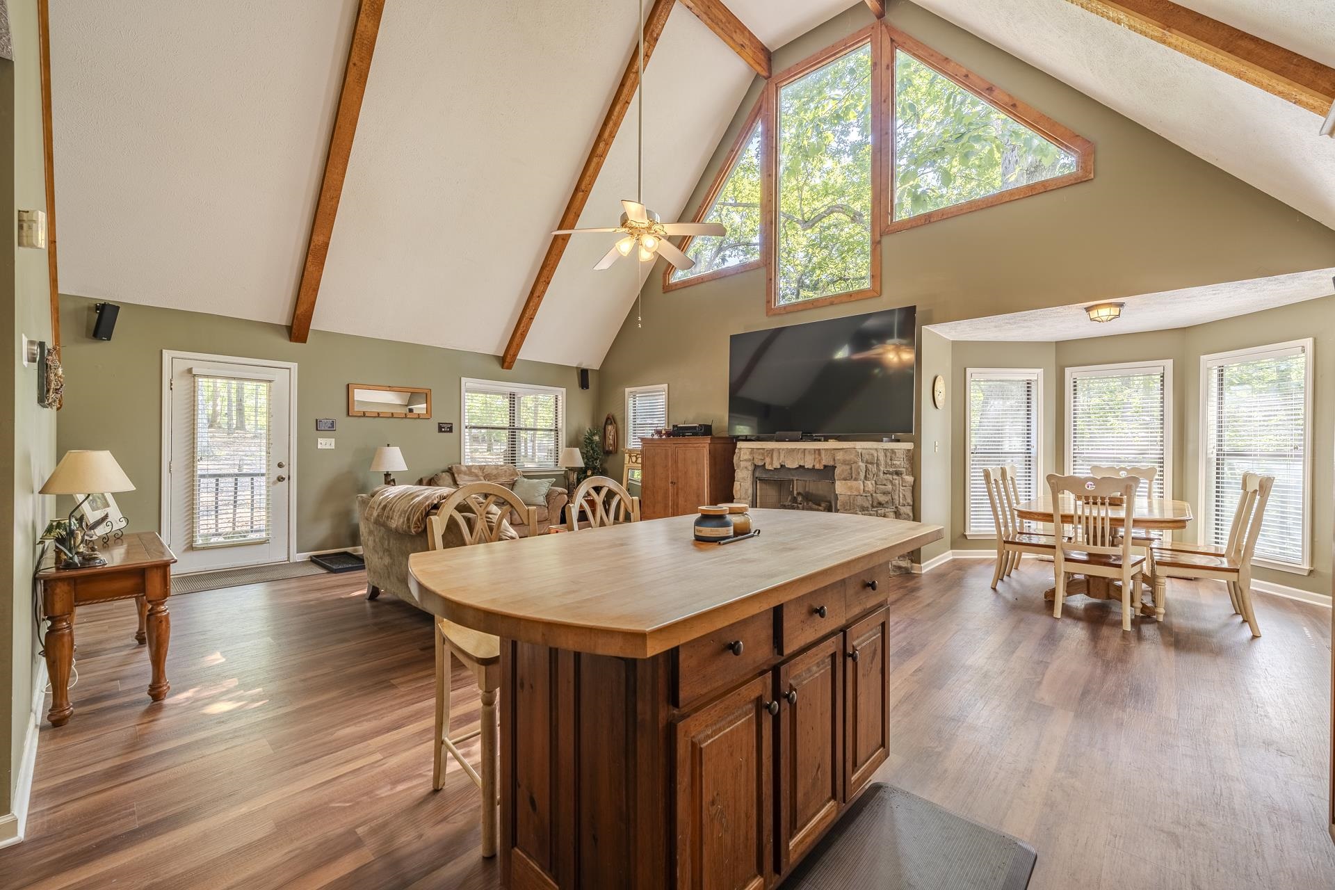435 Murray Lane Counce, TN 38326 - Photo 11 of 34 Vaulted ceiling with exposed wood beams, wood-finish flooring, and a stone-faced fireplace