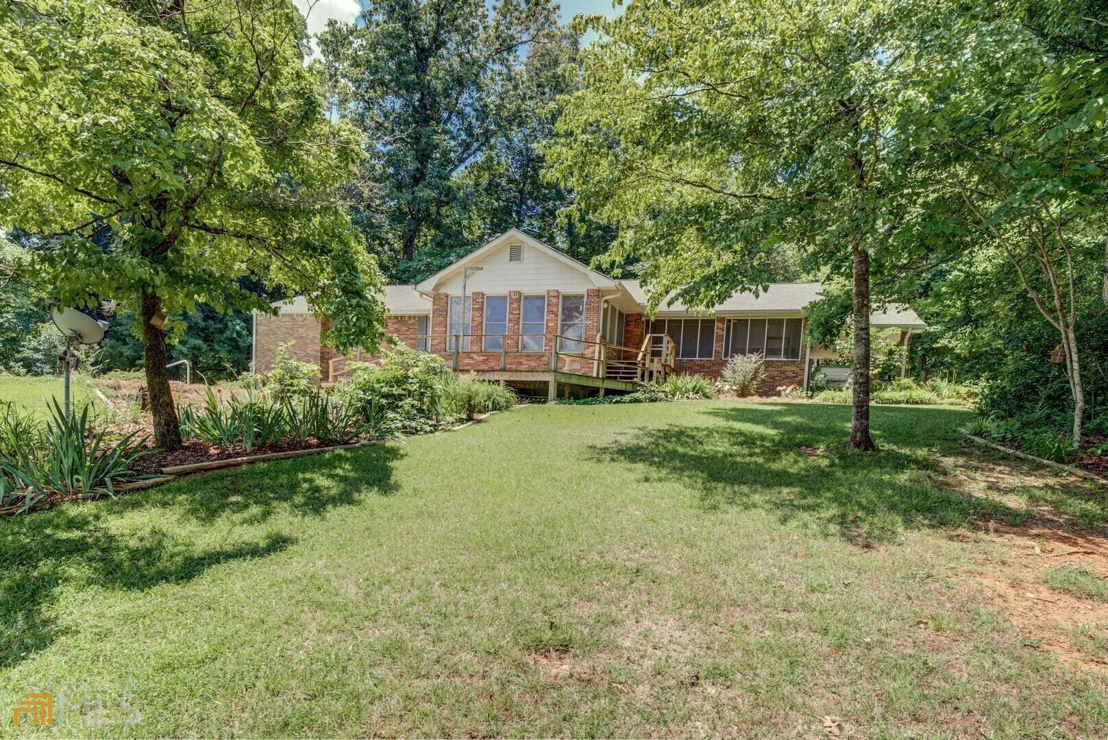 1670 Davis Ford Road Covington, GA 30014 - Photo 1 of 1 a view of a house with a big yard and large trees