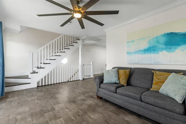 a living room with furniture and a ceiling fan
