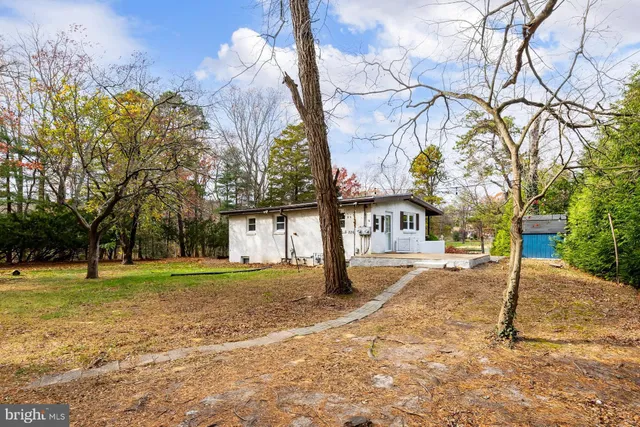 a front view of a house with a yard and trees
