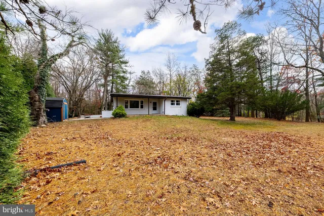a view of house with yard and basketball ground