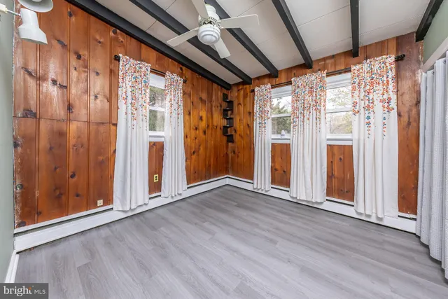 a view of an empty room with wooden floor and door