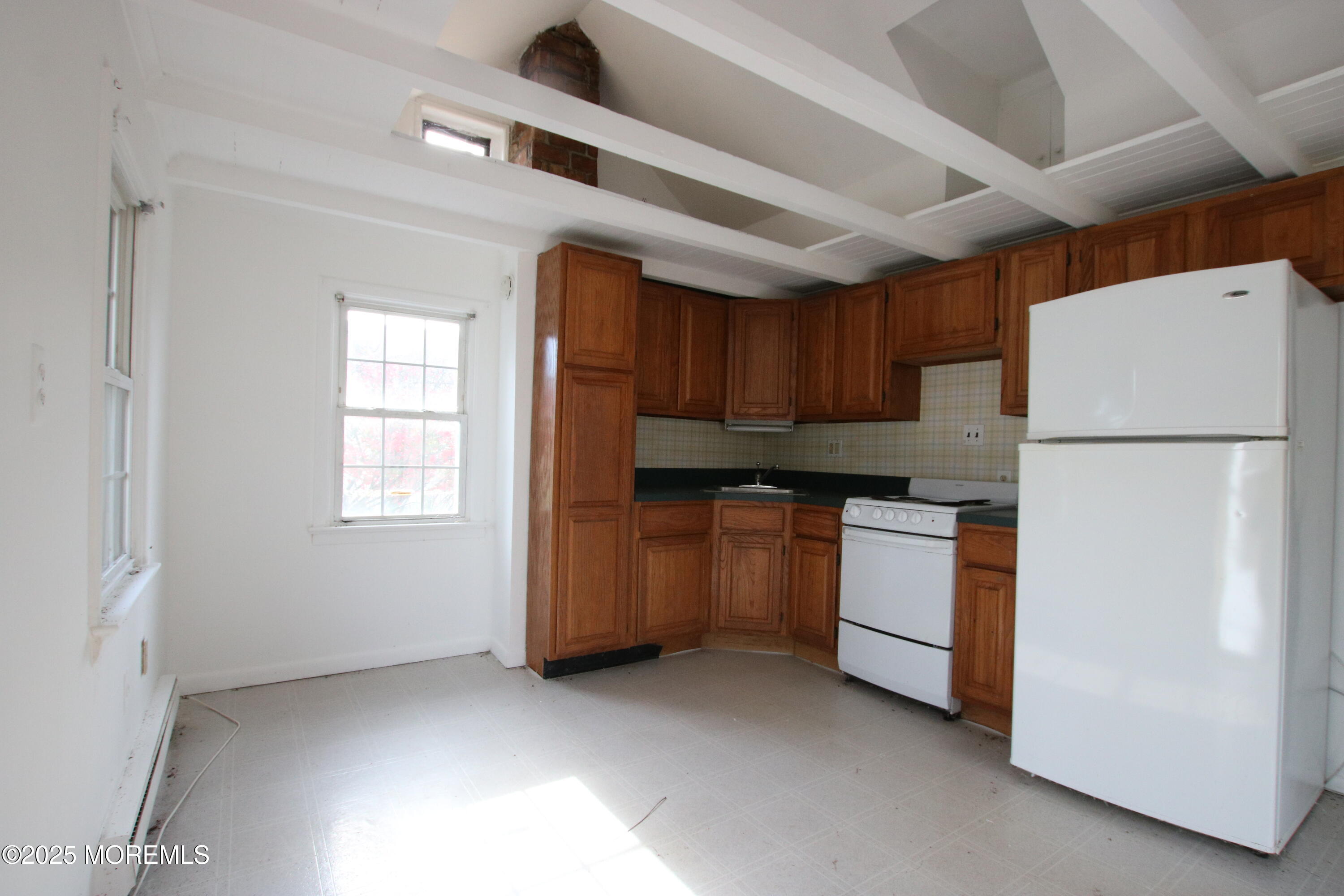 185 Monmouth Road West Long Branch, NJ 07764 - Photo 20 of 28 a kitchen with a refrigerator a stove top oven and cabinets