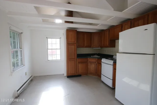 a kitchen with window and refrigerator