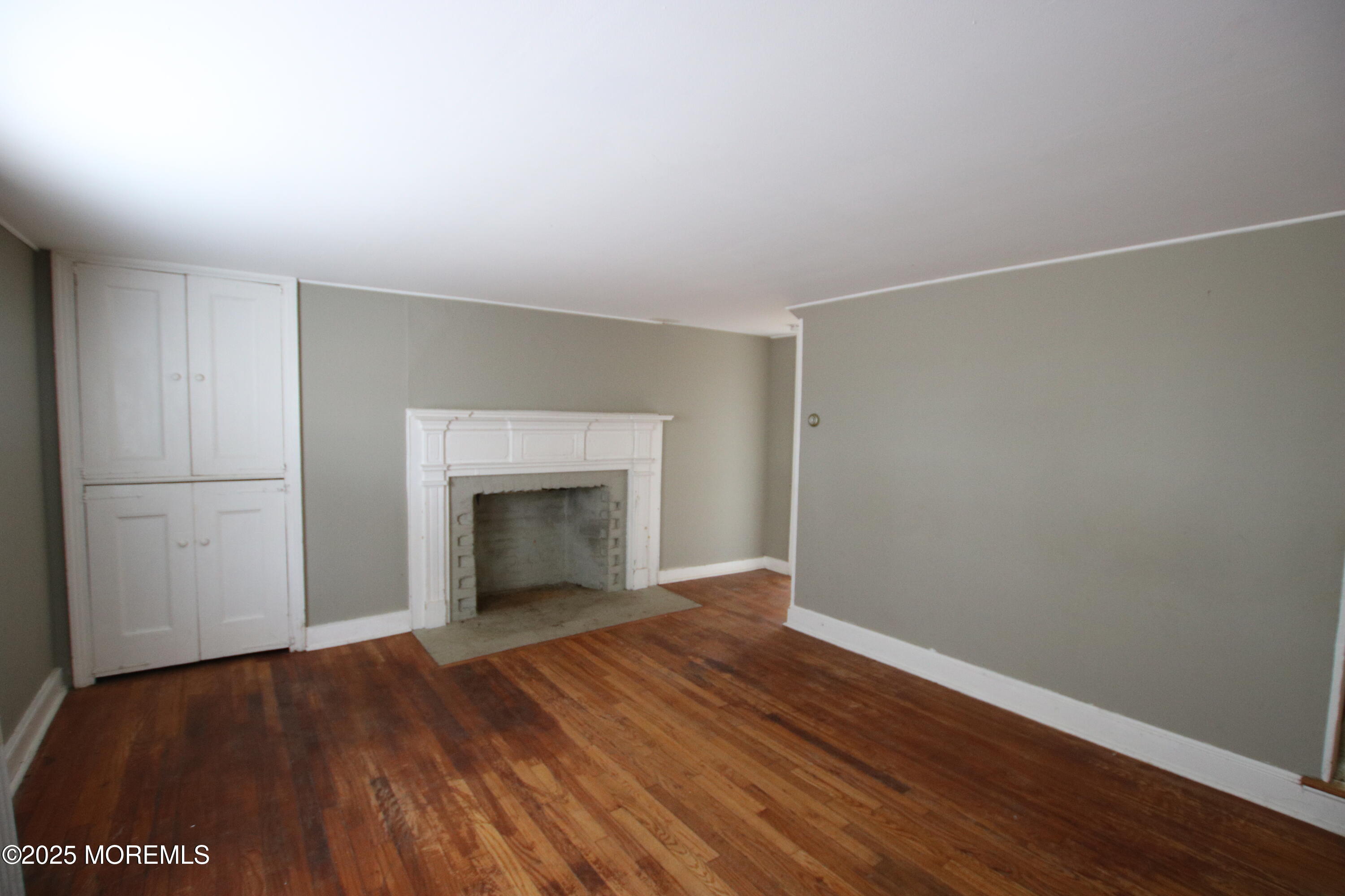 185 Monmouth Road West Long Branch, NJ 07764 - Photo 7 of 28 a view of an empty room with wooden floor and a window