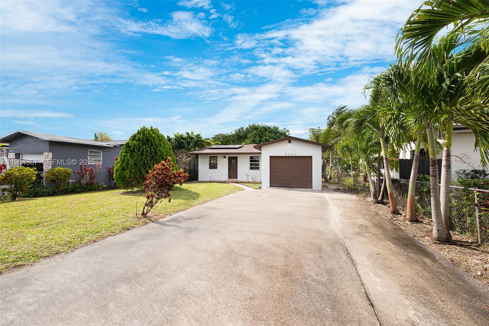 a front view of a house with a yard and trees