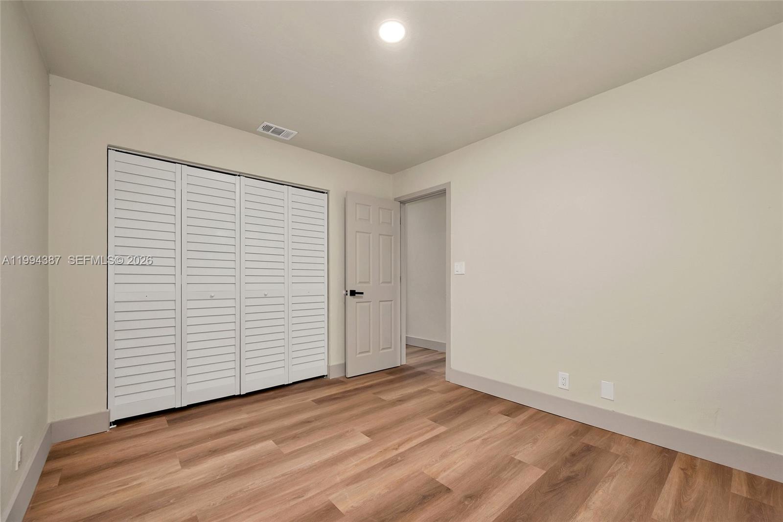 5632 Southwest 19th Street West Park, FL 33023 - Photo 11 of 43 an empty room with wooden floor and white walls