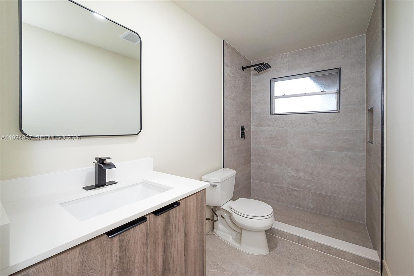 5632 Southwest 19th Street West Park, FL 33023 - Photo 22 of 43 a bathroom with a toilet a sink and mirror