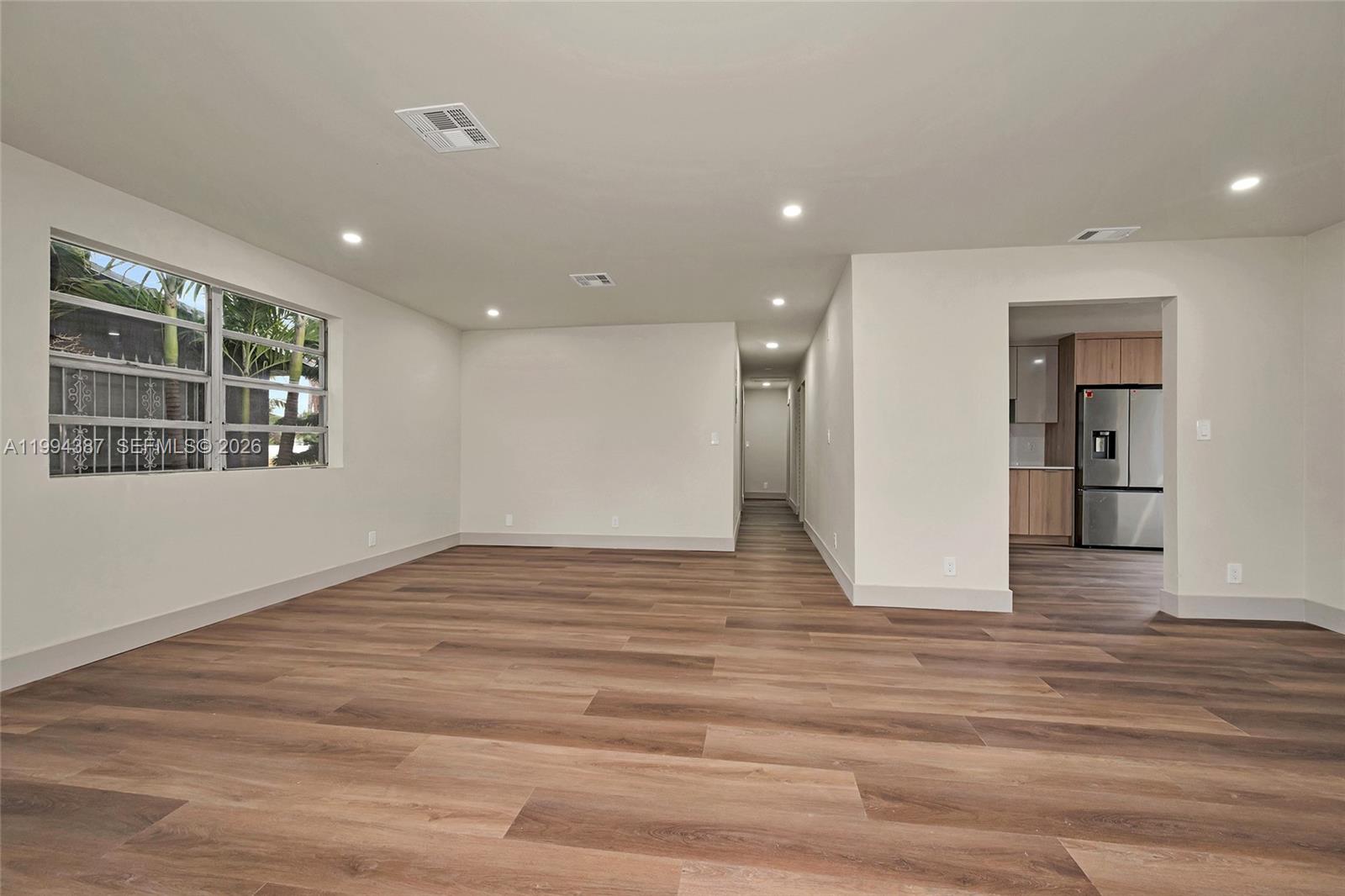 5632 Southwest 19th Street West Park, FL 33023 - Photo 4 of 43 a view of empty room with wooden floor and windows