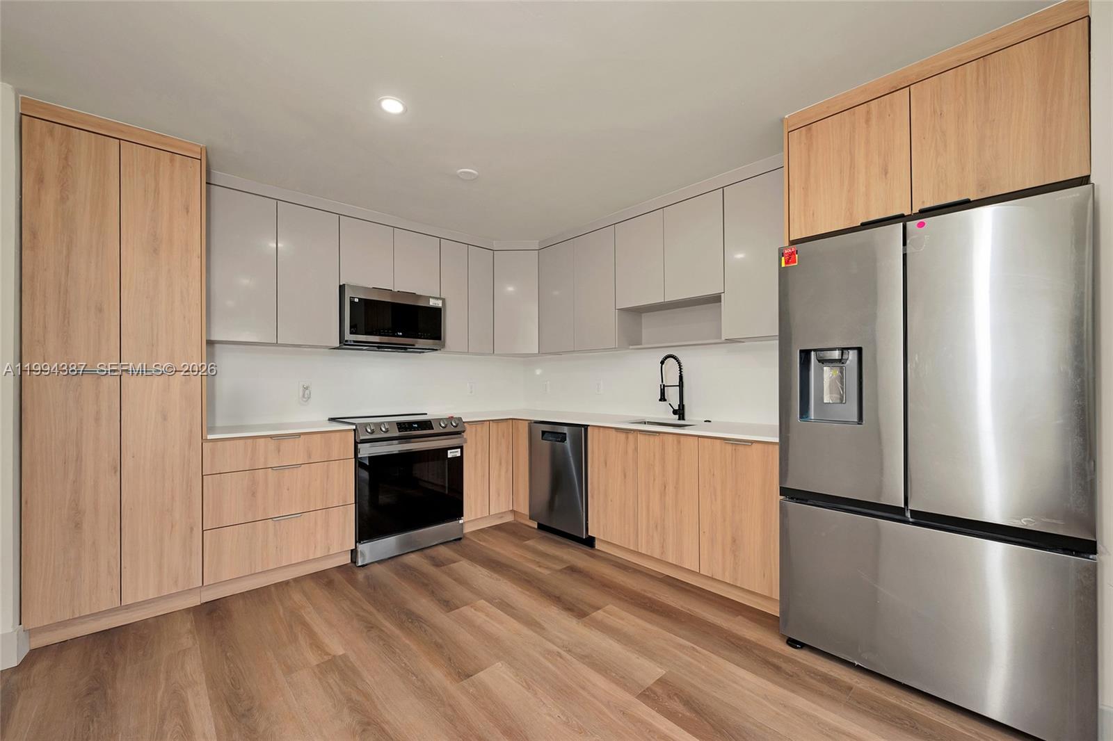 5632 Southwest 19th Street West Park, FL 33023 - Photo 9 of 43 a kitchen with a refrigerator a stove top oven and white cabinets