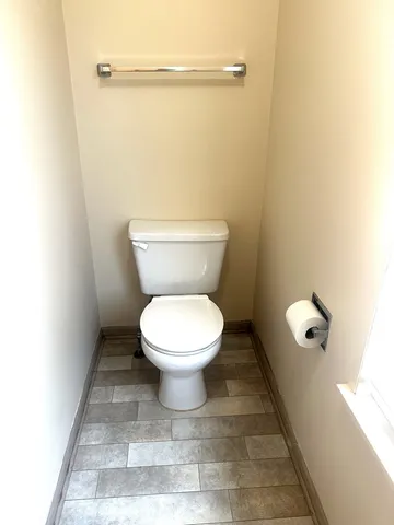 a white toilet sitting next to a shower