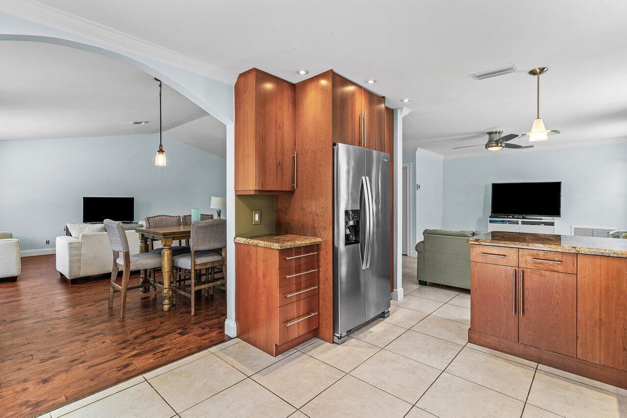 7800 Texas Trail Boca Raton, FL 33487 - Photo 11 of 33 a kitchen with stainless steel appliances kitchen island granite countertop a refrigerator and cabinets