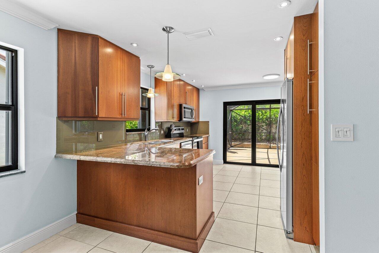 7800 Texas Trail Boca Raton, FL 33487 - Photo 12 of 33 a kitchen with stainless steel appliances granite countertop a sink and a cabinets