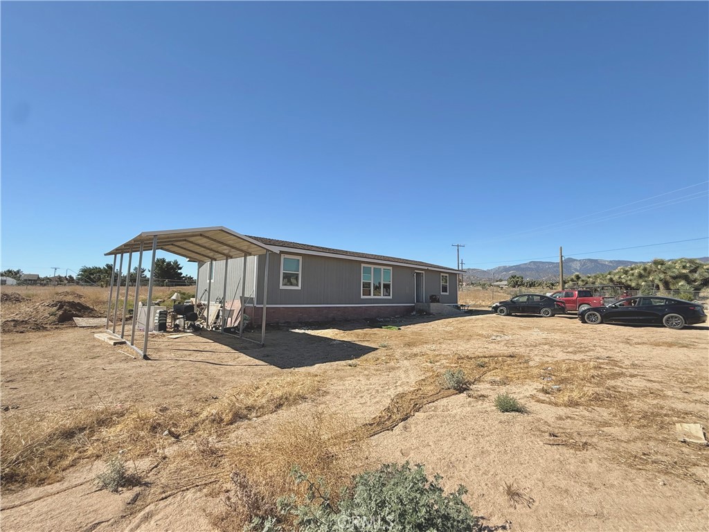 9589 Paramount Road Phelan, CA 92371 - Photo 5 of 29 a front view of a house with a yard covered with snow