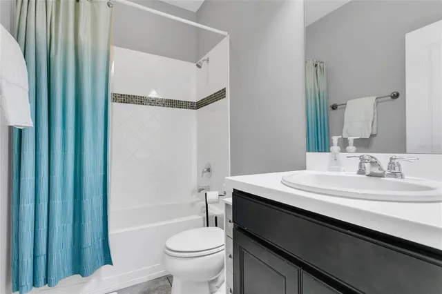 a bathroom with a sink a toilet a mirror and shower