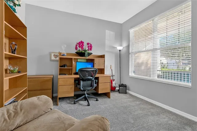 a view of a workspace with furniture and a window