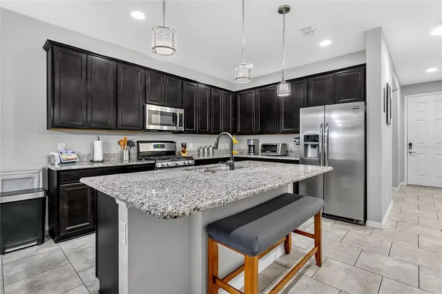 a kitchen with stainless steel appliances granite countertop a stove refrigerator and cabinets