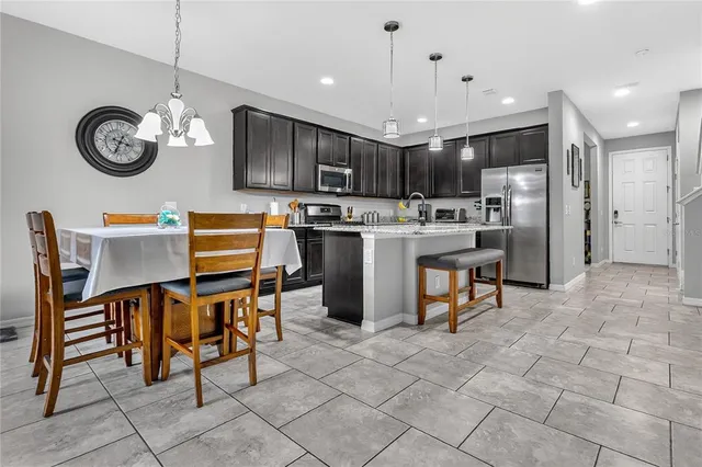 a view of kitchen with sink refrigerator dining table and chairs