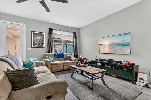 a living room with furniture a flat screen tv and a window