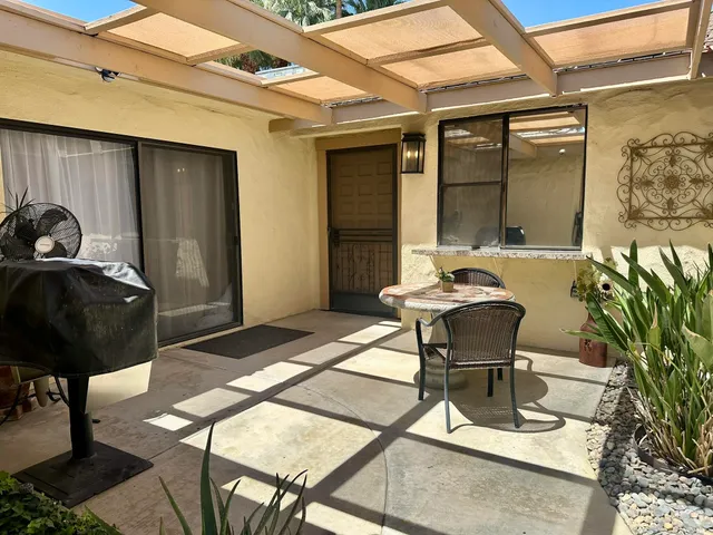 a view of a patio with table and chairs